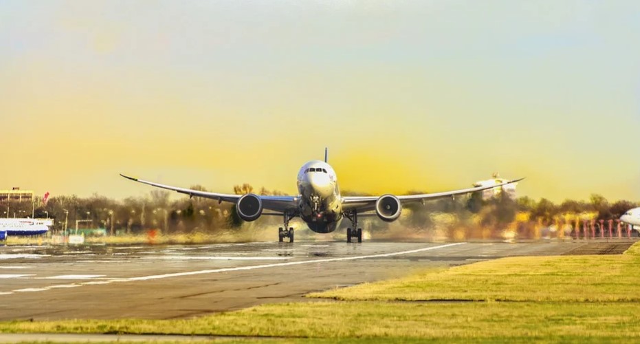 Um avião está em uma pista no aeroporto indo decolar durante o nascer do sol. Para que a sua agência de turismo tenha sucesso contrate o buscador de passagens com milhas