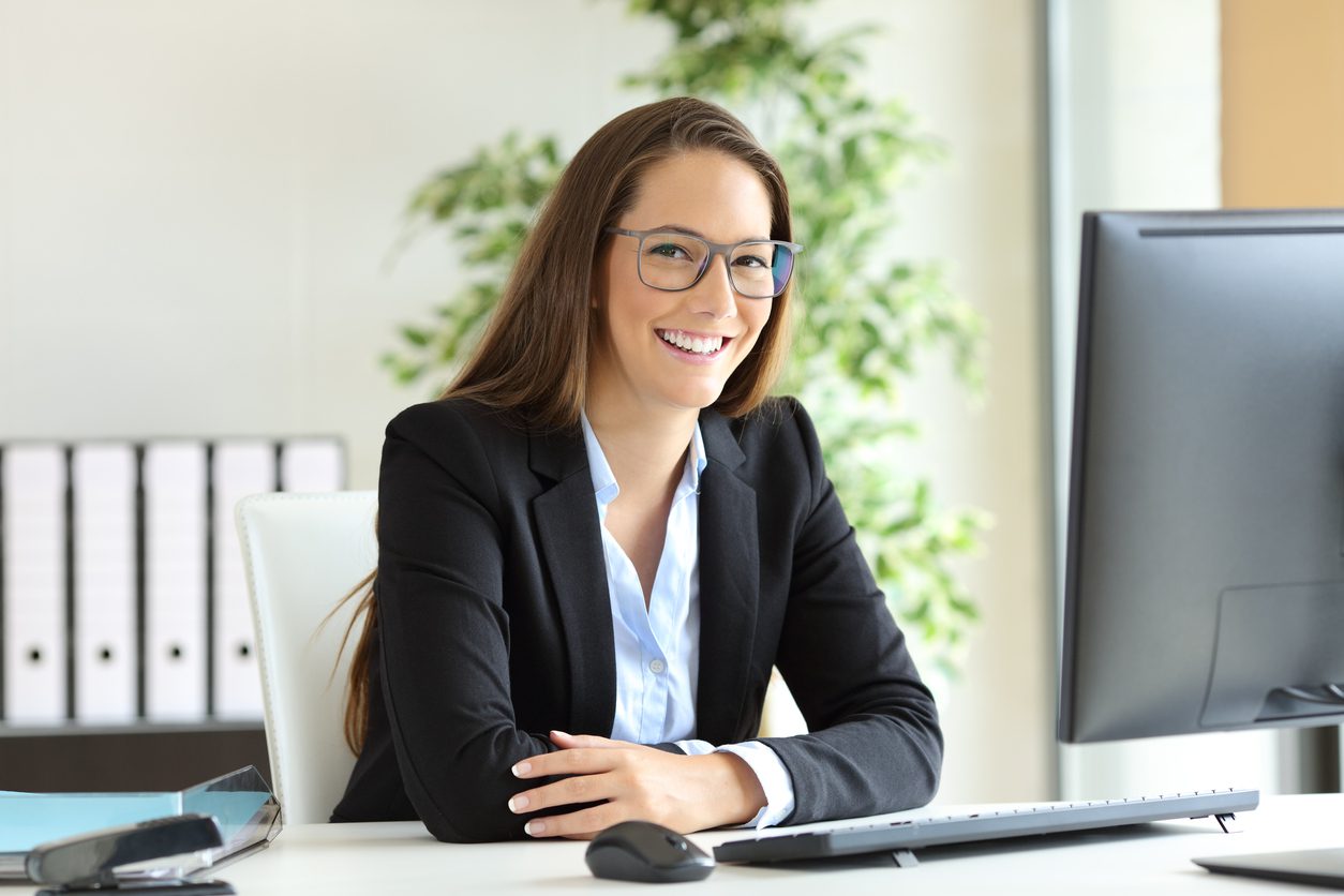 Empresária com óculos posando no escritório pensando se é melhor terceirizar serviços de buscador e gestão para sua empresa de milhas.