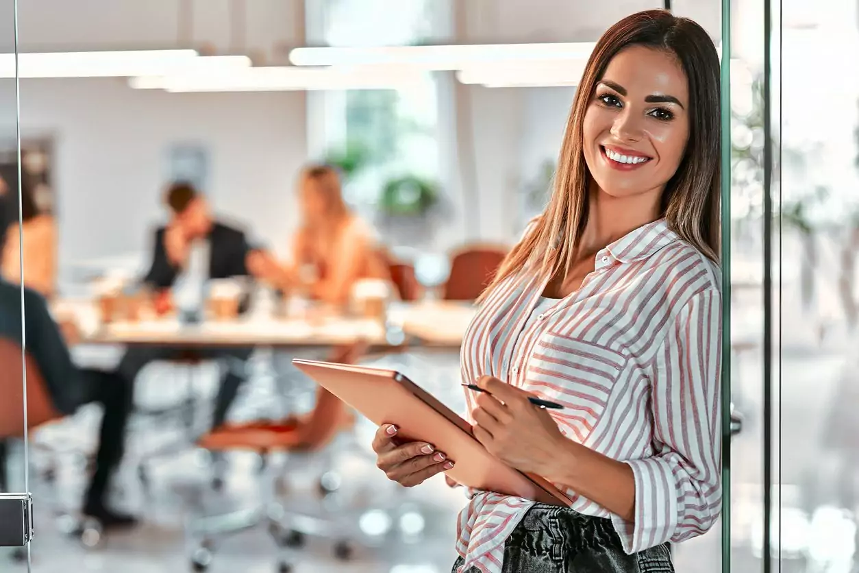 Retrato de uma jovem empresária sorridente usando tablet no escritório, avaliando como aumentar o estoque de milhas da suas empresa.